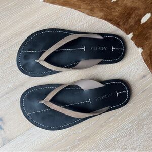 A. Amery Black and Tan Flip Flops